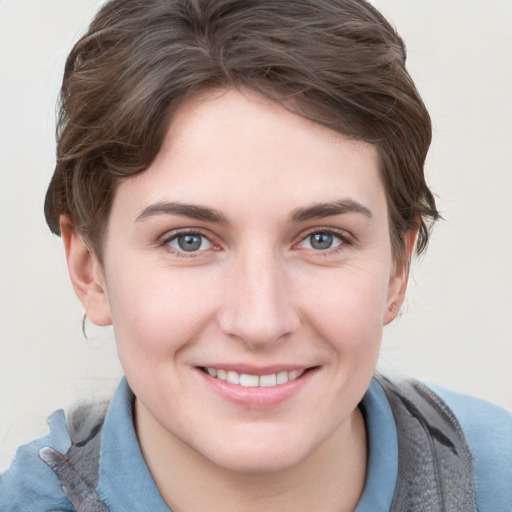 Joyful white young-adult female with short  brown hair and blue eyes