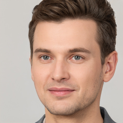 Joyful white young-adult male with short  brown hair and grey eyes