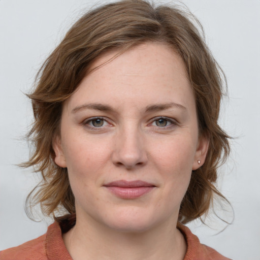 Joyful white young-adult female with medium  brown hair and blue eyes