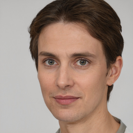 Joyful white adult male with short  brown hair and grey eyes