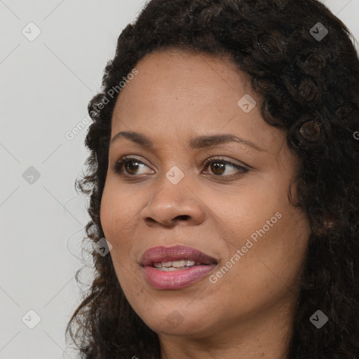 Joyful black adult female with long  brown hair and brown eyes