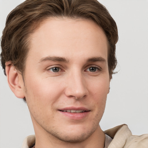 Joyful white young-adult male with short  brown hair and grey eyes