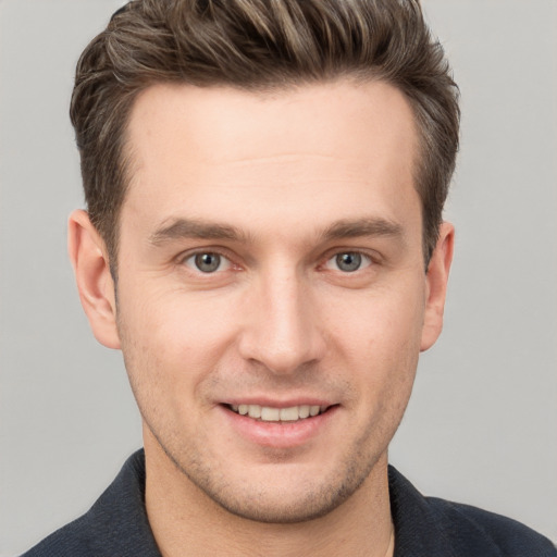 Joyful white young-adult male with short  brown hair and grey eyes