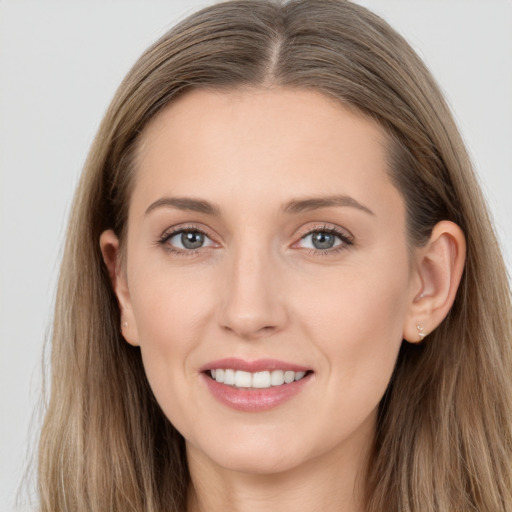 Joyful white young-adult female with long  brown hair and grey eyes