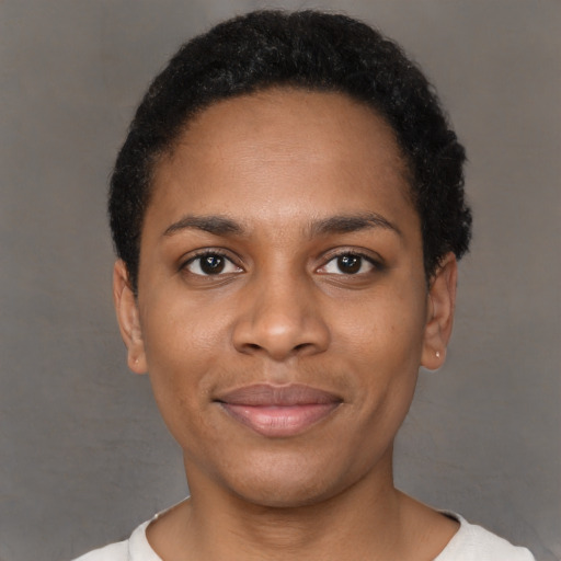 Joyful black young-adult female with short  black hair and brown eyes