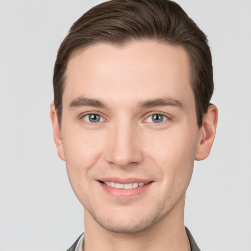 Joyful white young-adult male with short  brown hair and grey eyes