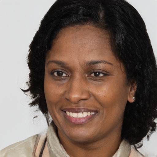 Joyful black adult female with medium  brown hair and brown eyes