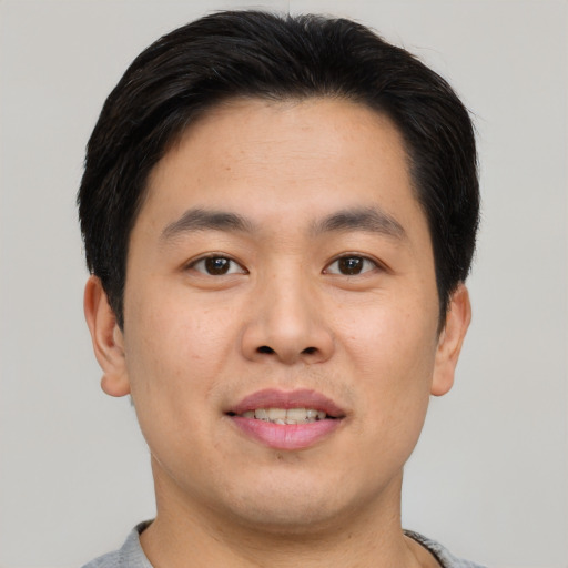 Joyful asian young-adult male with short  brown hair and brown eyes