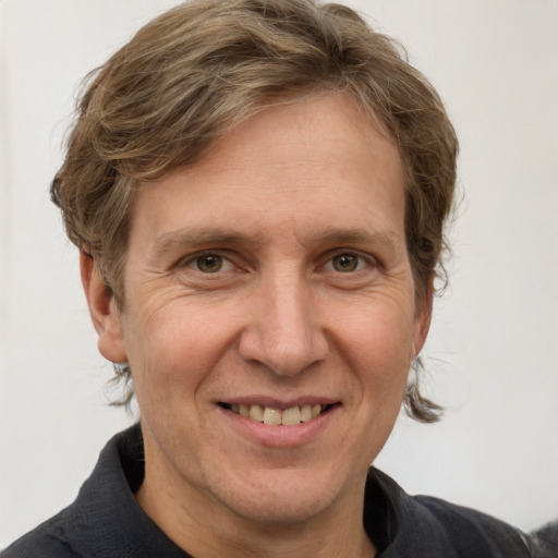 Joyful white adult male with short  brown hair and grey eyes