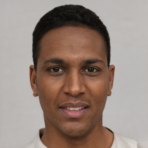 Joyful black young-adult male with short  black hair and brown eyes