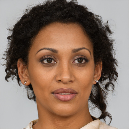 Joyful black adult female with medium  brown hair and brown eyes