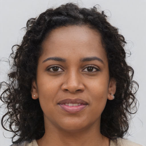 Joyful black young-adult female with long  brown hair and brown eyes