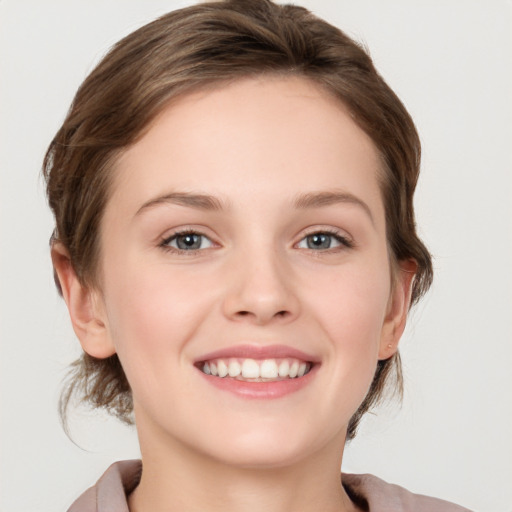 Joyful white young-adult female with medium  brown hair and grey eyes