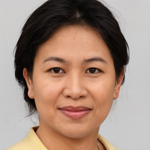 Joyful asian adult female with medium  brown hair and brown eyes