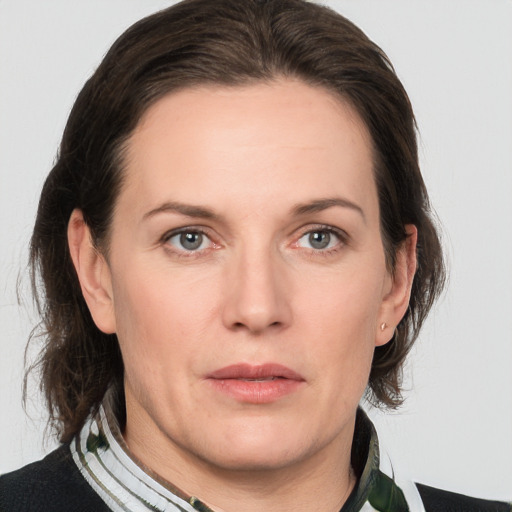 Joyful white adult female with medium  brown hair and grey eyes