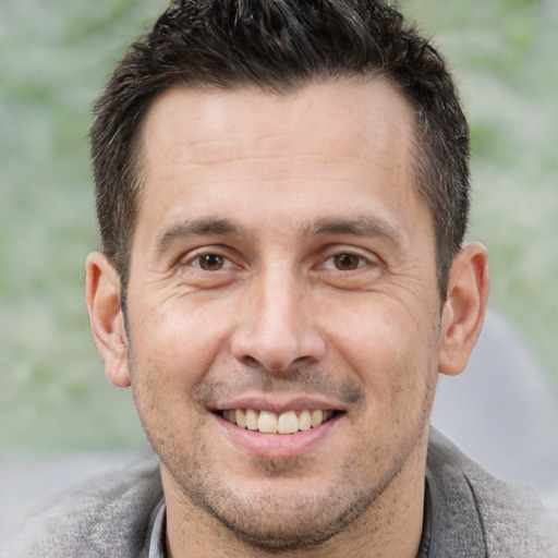 Joyful white adult male with short  brown hair and brown eyes