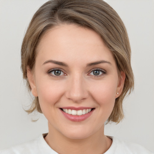 Joyful white young-adult female with medium  brown hair and grey eyes