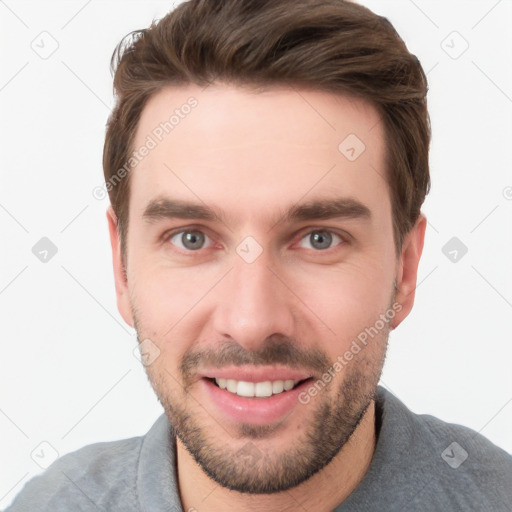 Joyful white young-adult male with short  brown hair and grey eyes