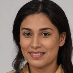 Joyful latino adult female with medium  brown hair and brown eyes