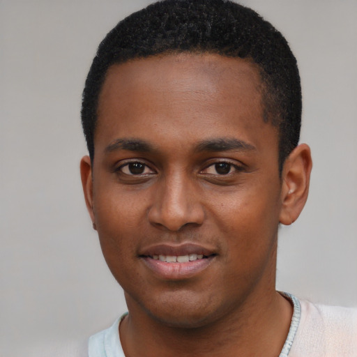 Joyful black young-adult male with short  black hair and brown eyes