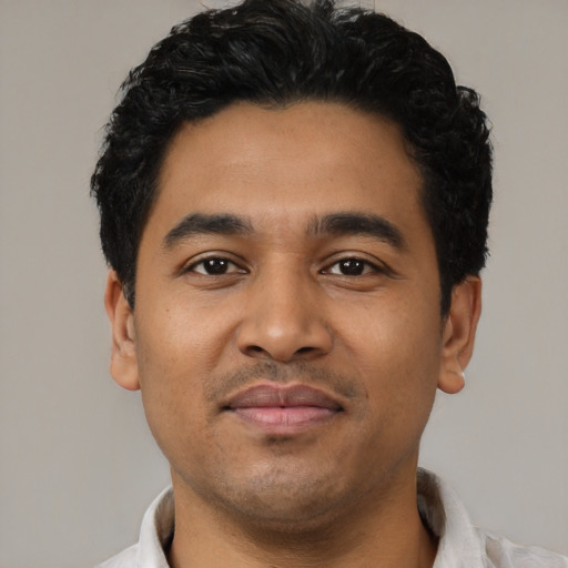 Joyful latino young-adult male with short  black hair and brown eyes