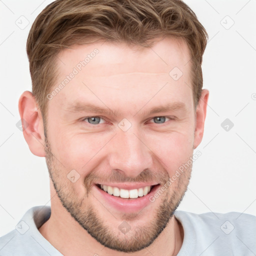 Joyful white young-adult male with short  brown hair and grey eyes