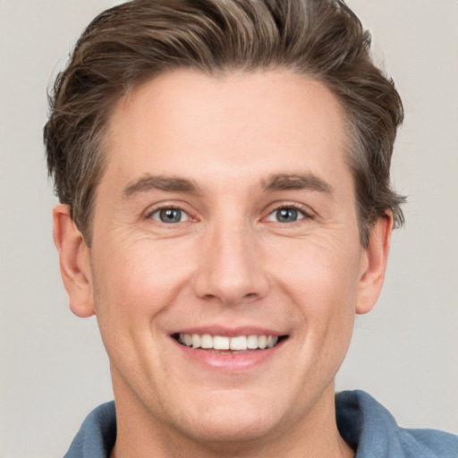 Joyful white adult male with short  brown hair and grey eyes