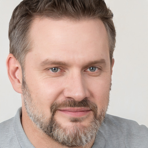 Joyful white adult male with short  brown hair and grey eyes