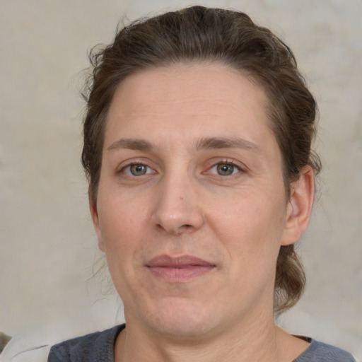 Joyful white adult female with medium  brown hair and grey eyes