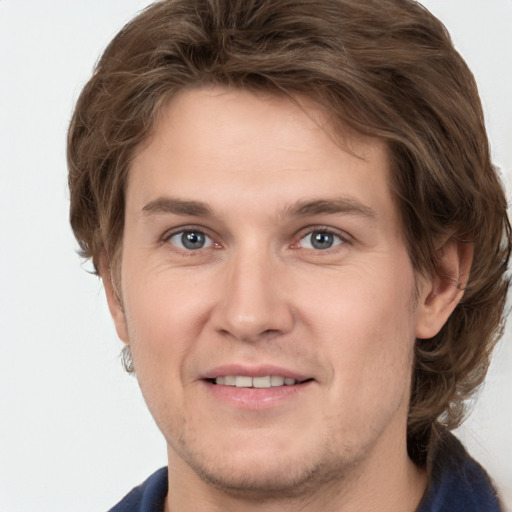 Joyful white young-adult male with short  brown hair and grey eyes