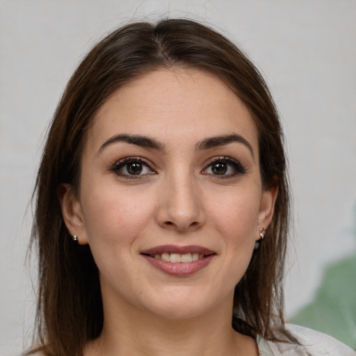 Joyful white young-adult female with medium  brown hair and grey eyes