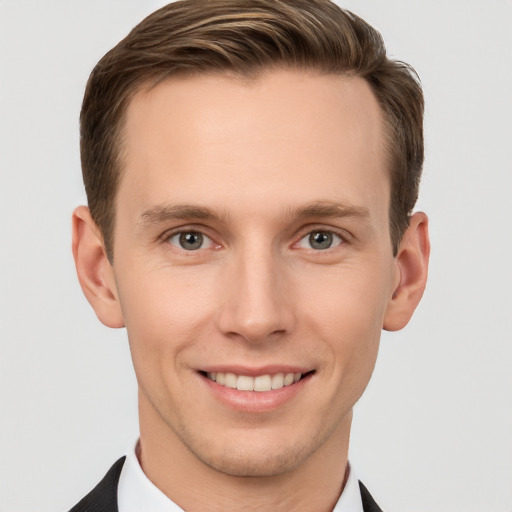 Joyful white young-adult male with short  brown hair and grey eyes