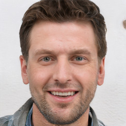 Joyful white young-adult male with short  brown hair and grey eyes