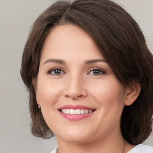 Joyful white young-adult female with medium  brown hair and brown eyes