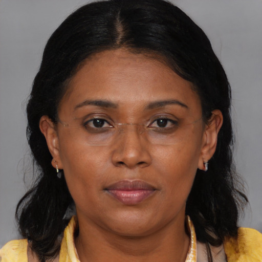 Joyful black adult female with medium  brown hair and brown eyes