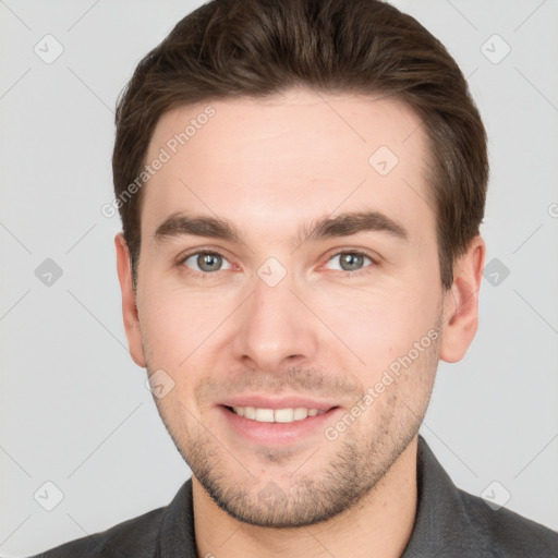 Joyful white young-adult male with short  brown hair and grey eyes