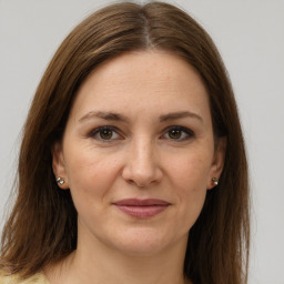 Joyful white adult female with long  brown hair and brown eyes