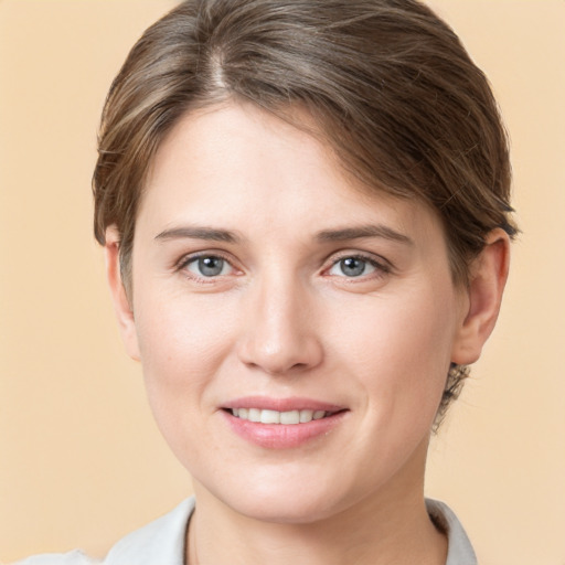 Joyful white young-adult female with short  brown hair and grey eyes