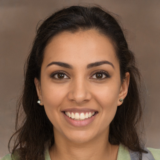 Joyful latino young-adult female with long  brown hair and brown eyes