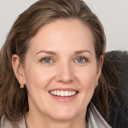 Joyful white young-adult female with long  brown hair and grey eyes