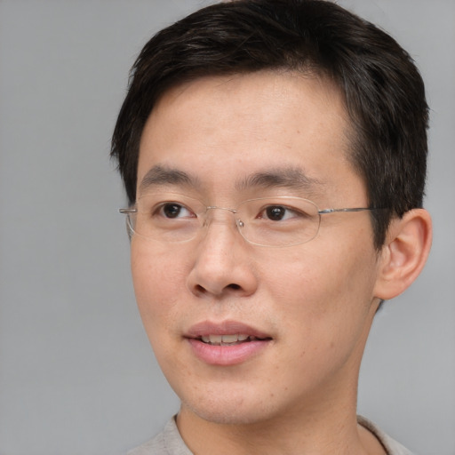 Joyful asian adult male with short  brown hair and brown eyes