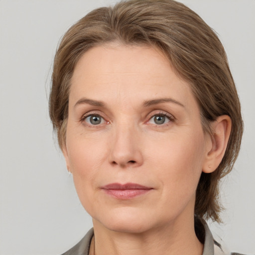 Joyful white adult female with medium  brown hair and grey eyes