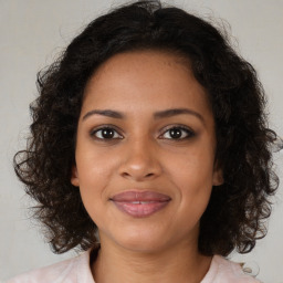 Joyful black young-adult female with medium  brown hair and brown eyes