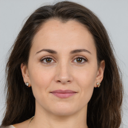 Joyful white young-adult female with long  brown hair and brown eyes