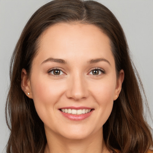 Joyful white young-adult female with long  brown hair and brown eyes