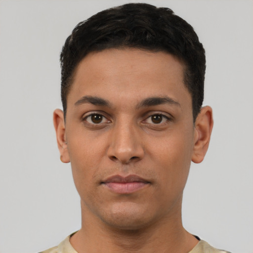 Joyful latino young-adult male with short  black hair and brown eyes