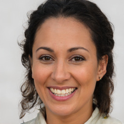 Joyful latino adult female with medium  brown hair and brown eyes