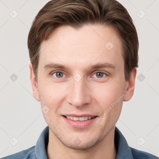 Joyful white young-adult male with short  brown hair and grey eyes