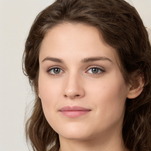 Joyful white young-adult female with long  brown hair and green eyes