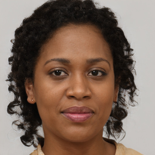 Joyful black adult female with medium  brown hair and brown eyes